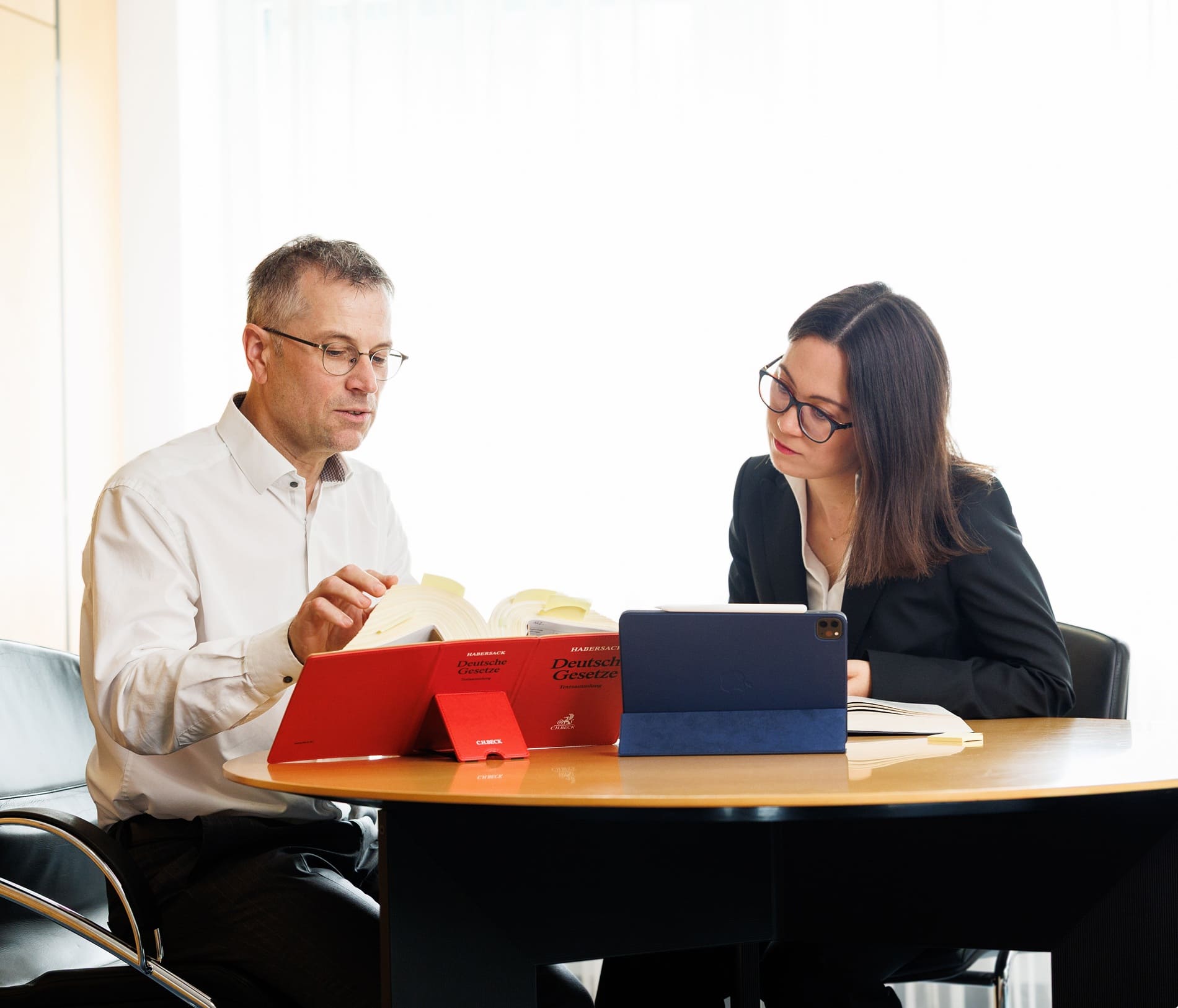 Zwei Personen beraten sich am Besprechungstisch.